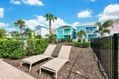 a row of white chairs in front of houses at Inviting Cottage With Private Pool Near Disney With Margaritaville Resort & Island H2O Access - 8022Kd in Orlando