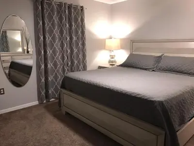 a bedroom with a bed and a mirror at Sunny South Facing Pool with Hot Tub and Lake View Near Disney in Kissimmee