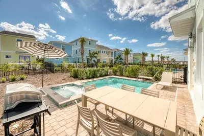a patio with a table and chairs next to a swimming pool at Sunset Dream Cottage With Private Pool Near Disney With Margaritaville Resort & Island H2O Access - 8029Kd in Orlando