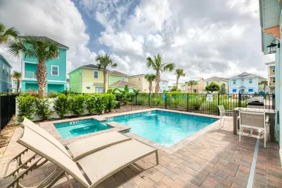 a pool with chairs and a table next to a building at Chat Eau Champagne Cottage With Private Pool Near Disney With Margaritaville Resort & Island H2O Access - 8030Kd in Orlando