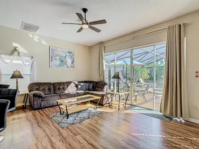 a living room with a couch and a table at Family retreat w pool, spa & BBQ grill in Orlando