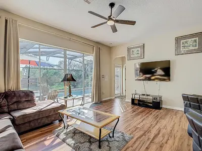 a living room with a couch and a ceiling fan at Family retreat w pool, spa & BBQ grill in Orlando