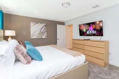 a bedroom with a bed with a television on the wall at Gorgeous 4 Bd w/ Pool Close to Disney @ Storey Lake 2963 in Kissimmee