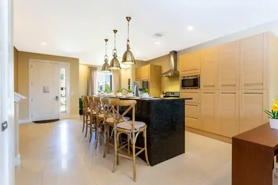 a kitchen with a bar with chairs and a counter at Stunning 4 Bd Close To Disney @ Magic Village 3247 in Orlando