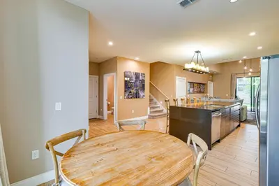 a kitchen and dining room with a wooden table at Magic Villas Townhome about 5 Mi to Disney Parks! in Orlando