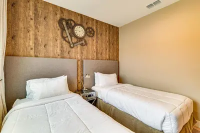 two beds in a room with a clock on the wall at Magic Villas Townhome about 5 Mi to Disney Parks! in Orlando