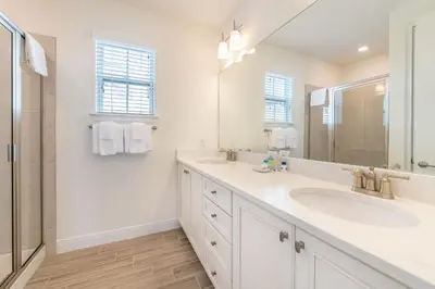 a white bathroom with a sink and a mirror at Sunburnt Cottage With Hot Tub Near Disney With Margaritaville Resort & Island H2O Access - 8041Sh in Orlando