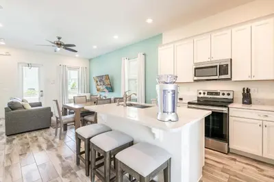 a kitchen with white cabinets and a counter with a blender at Seaweed Paradise Cottage Near Disney With Margaritaville Resort & Island H2O Access - 8057Kd in Orlando