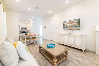 a living room with a white couch and a table at Inviting Cottage With Private Hot Tub Near Disney With Margaritaville Resort & Island H2O Access - 8072Dr in Orlando