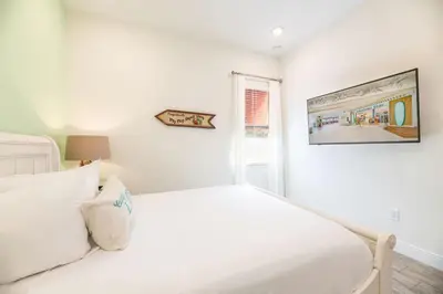 a white bedroom with a white bed and a window at Inviting Cottage With Private Hot Tub Near Disney With Margaritaville Resort & Island H2O Access - 8072Dr in Orlando