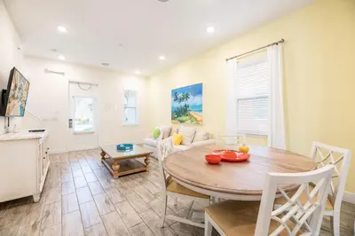a living room with a table and a couch at Inviting Cottage With Private Hot Tub Near Disney With Margaritaville Resort & Island H2O Access - 8072Dr in Orlando