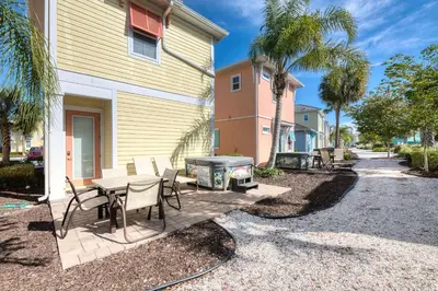a patio with a table and chairs and a grill at Inviting Cottage With Private Hot Tub Near Disney With Margaritaville Resort & Island H2O Access - 8072Dr in Orlando