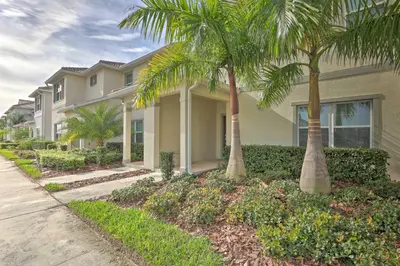 a house with palm trees in front of it at 5 Mi to Disney Chic Townhome with Community Perks! in Kissimmee