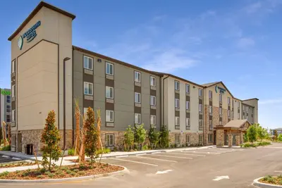 an exterior view of a building with a parking lot at WoodSpring Suites Orlando I-4 & Convention Center in Orlando