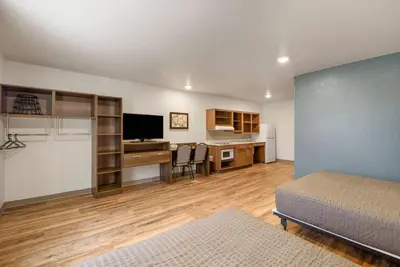 a bedroom with a bed and a desk with a computer at WoodSpring Suites Orlando I-4 & Convention Center in Orlando