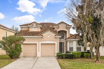 a house with a garage in front of it at Disney Vacation Oasis Pool BBQ Resort Fun in Orlando