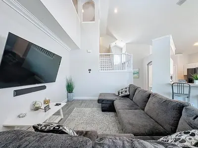a living room with a couch and a flat screen tv at Amazing 6 Bed Disney Dream Getaway in Windsor Palm villa in Kissimmee