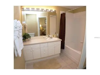 a bathroom with a sink and a mirror and a tub at 3 Bedroom,3 Bath Townhouse in Gate Resort townhouse in Kissimmee
