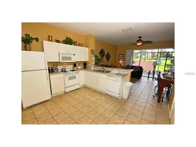 a kitchen with white appliances and a living room at 3 Bedroom,3 Bath Townhouse in Gate Resort townhouse in Kissimmee