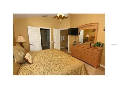 a bedroom with a bed and a dresser and a mirror at 3 Bedroom,3 Bath Townhouse in Gate Resort townhouse in Kissimmee