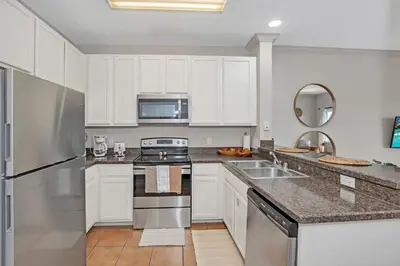 a kitchen with white cabinets and stainless steel appliances at -Relaxing 3BR Near Disney - Pool in Orlando