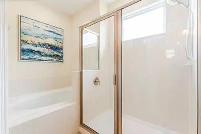 a bathroom with a shower with a glass door at Encore Resort 6 Bedroom Home with Pool 2300 in Orlando