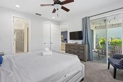 a bedroom with a bed and a tv and a balcony at 360 Pendant Ct · 360 Villa - 7BD - Pool Theme Beds by Disney in Orlando