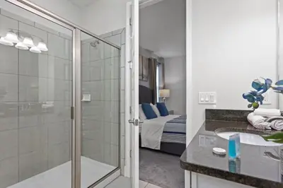 a bathroom with a shower and a sink and a bed at 360 Pendant Ct · 360 Villa - 7BD - Pool Theme Beds by Disney in Orlando