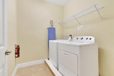 a laundry room with a washer and dryer at 360 Pendant Ct · 360 Villa - 7BD - Pool Theme Beds by Disney in Orlando