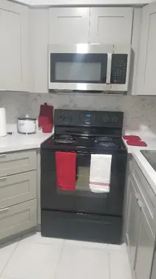 a kitchen with a black stove with a microwave at 3697 Orlando Vacational Apartment in Orlando