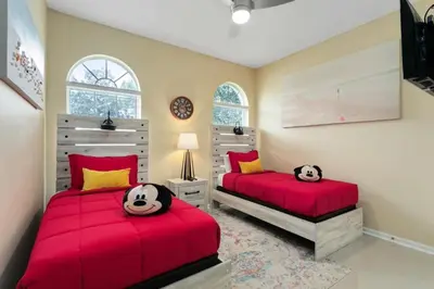 two beds in a bedroom with red sheets at Amazing Disney Dream Getaway in Windsor Palms! villa in Kissimmee