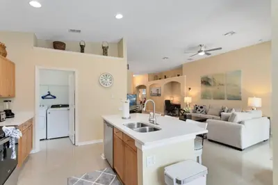 a kitchen and living room with a sink and a couch at Amazing Disney Dream Getaway in Windsor Palms! villa in Kissimmee