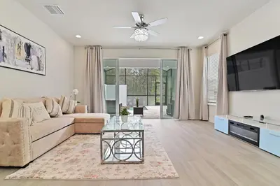 a living room with a couch and a tv at New Cozy & Spacious Townhouse near Disney - 4BR, 3FB, and Pool in Orlando