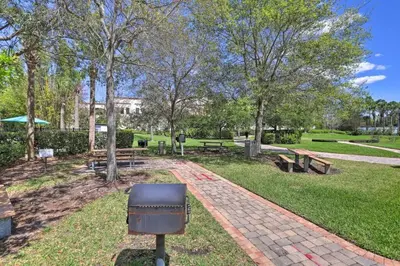 a park with benches and a grill in the grass at SeaworldDisneyUniversal Villa 5 beds 3 bed2bath in Orlando
