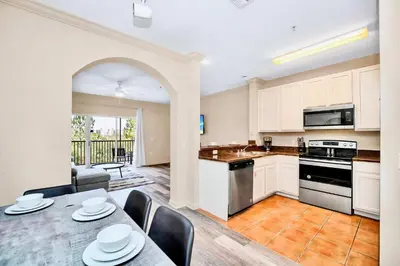 a kitchen and dining room with a table and chairs at 2BR Condo with shared Pool near Disney! in Orlando