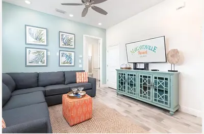 a living room with a couch and a flat screen tv at ZAY & ZAC’S SHAKE SHACK in Orlando