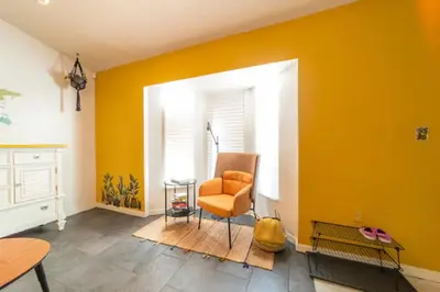 an orange chair in a room with a yellow wall at Newly Updated 3 Bedroom Home in Kissimmee