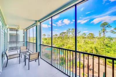 a balcony with two chairs and a table and benches at Stunning 2BR Condo with Pool, near Disney! in Orlando