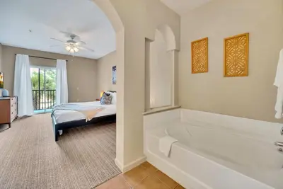a large bathroom with a tub and a bed at Bright 3BR Condo With Pool, Close to Disney! in Orlando