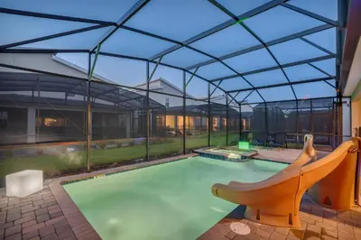 an indoor swimming pool with a glass roof at Mickey Mouse ClubHouse 8min Disneyworld Pool Spa Sleeps 20 in Kissimmee
