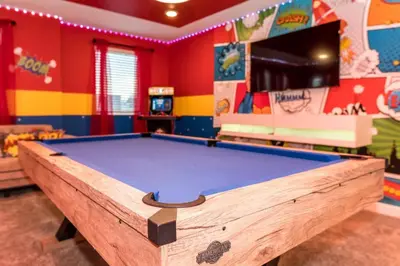 a pool table in a play room with a tv at Mickey Mouse ClubHouse 8min Disneyworld Pool Spa Sleeps 20 in Kissimmee