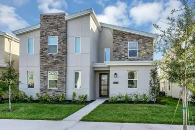 a large white house with a grass yard at Amazing Family Home 8min Disneyworld Pool/Spa Sleeps 24 in Kissimmee