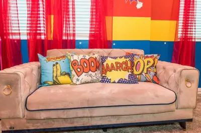 a brown couch with colorful pillows on it at Magical Family Home 8min Disneyworld Pool/Spa Sleeps 22 in Kissimmee