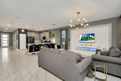 a living room with two couches and a kitchen at Magical Family Home 8min Disneyworld Pool/Spa Sleeps 22 in Kissimmee