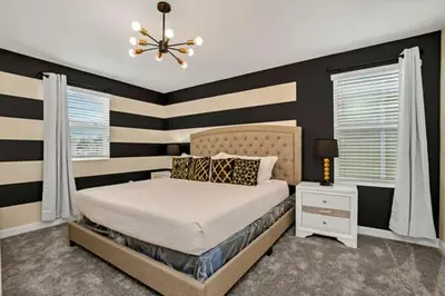 a bedroom with a bed and a black and white striped wall at Magical Family Home 8min Disneyworld Pool/Spa Sleeps 22 in Kissimmee