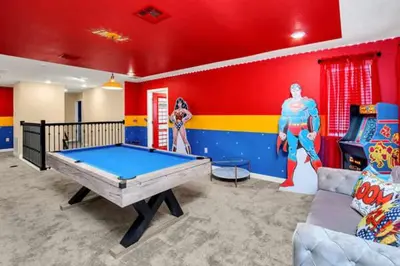a room with a pool table and a superhero themed room at Magical Family Home 8min Disneyworld Pool/Spa Sleeps 22 in Kissimmee