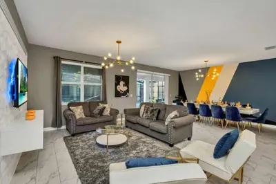 a living room with couches and a dining room at Disney Decorated Home 8min Disneyworld Pool/Spa Sleeps 22 in Kissimmee