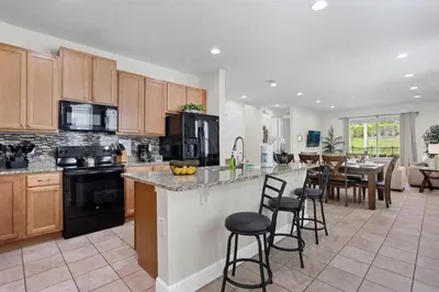 a kitchen with wooden cabinets and a kitchen island with bar stools at 7500 Marker av in Orlando
