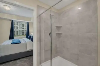 a bathroom with a shower and a bedroom with a bed at 3 BR 2 BA Deluxe Condo 8min to Disneyworld STL105 in Kissimmee
