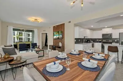 a living room with a dining table and a kitchen at 3 BR 2 BA Deluxe Condo 8min to Disneyworld STL105 in Kissimmee